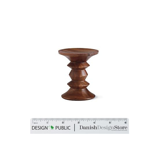 "Brown wooden stool with a smooth, rounded shape and decorative tapered pattern."
