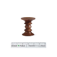 "Brown wooden stool with a smooth, rounded shape and decorative tapered pattern."