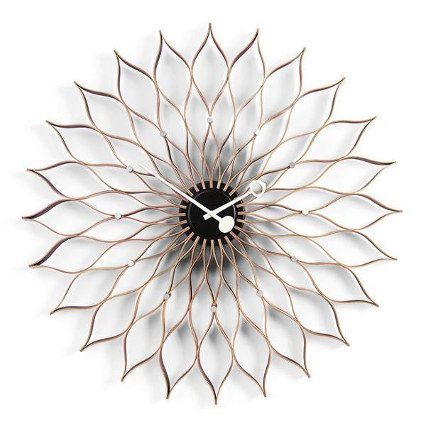 Bronze sunburst wall clock with intricate petal-like design and black center, adding elegance to any decor.