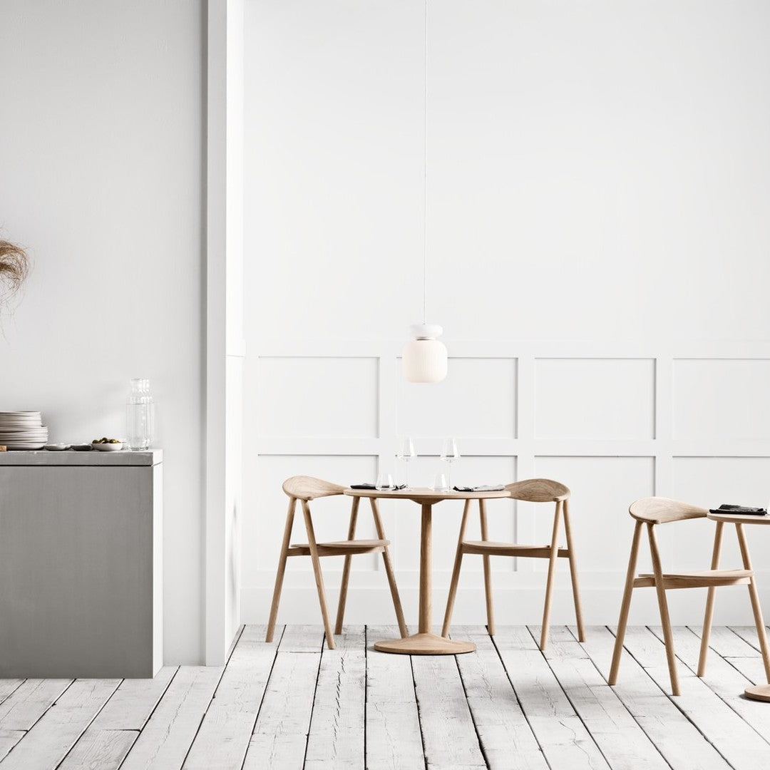 Modern wood dining set with light oak chairs and tabletop, complemented by a minimalistic white and gray color scheme.