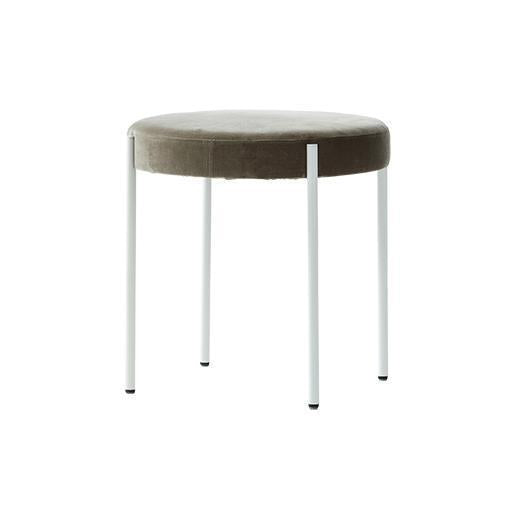 Round velvet stool in soft taupe with sleek white metal legs, featuring a minimalist design and contemporary style.