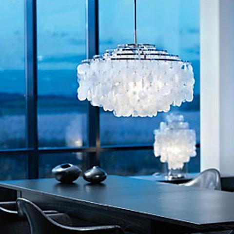 "Elegant chrome chandelier with textured white glass, casting soft light against a serene blue backdrop."