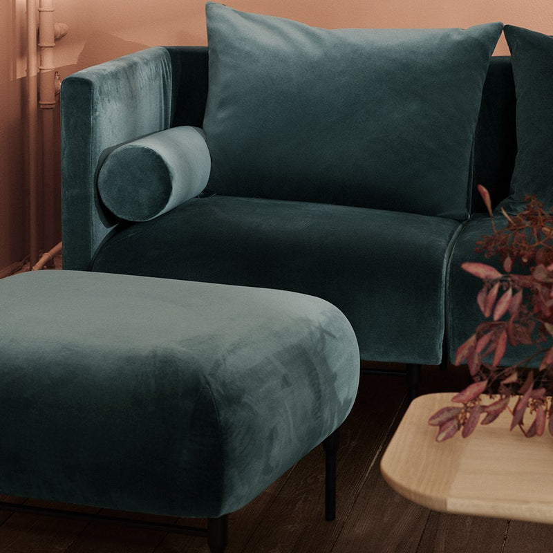 Teal velvet sofa and ottoman with soft textures, perfect for modern decor.