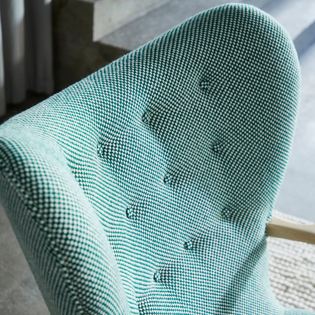 Textured mint green chair with a houndstooth pattern and button detailing. Modern design for stylish interiors.
