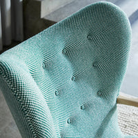 Textured mint green chair with a houndstooth pattern and button detailing. Modern design for stylish interiors.