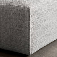 Gray textured fabric corner of a modern furniture piece, featuring subtle variations in color and pattern.