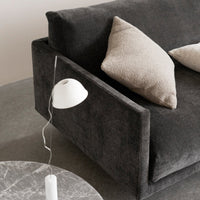 Stylish dark gray sofa with beige pillows, featuring a sleek, minimalist design and soft textures. Perfect for modern decor.