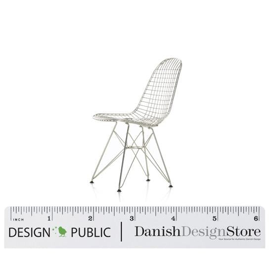 White wire mesh chair with a sleek modern design, featuring an intricate grid pattern and black tapered legs.